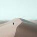 This minimal stark composition captures a tiny human form making its way across endless waves of sand. With gentle tones and extreme negative space, the image becomes a meditation on scale, solitude, and purpose